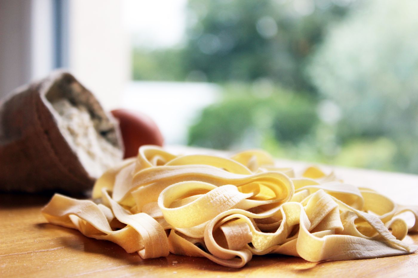 Fresh tagliatelle nests on a wooden board