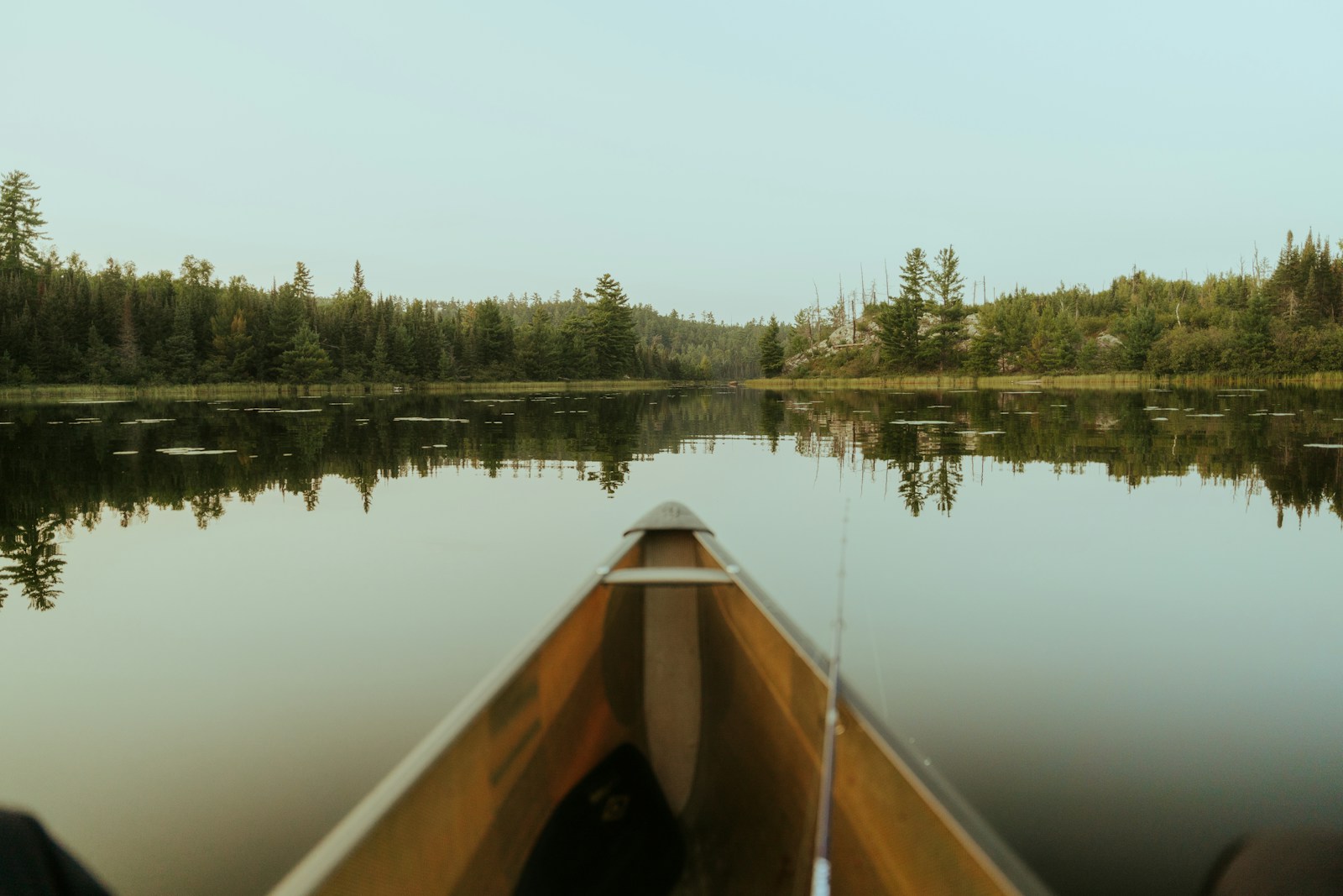 A canoe drawn up on the calm surface of the lake
